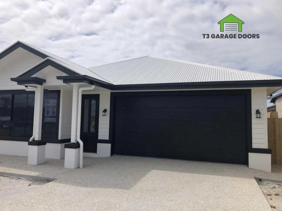Newly installed sectional garage door on a rendered home