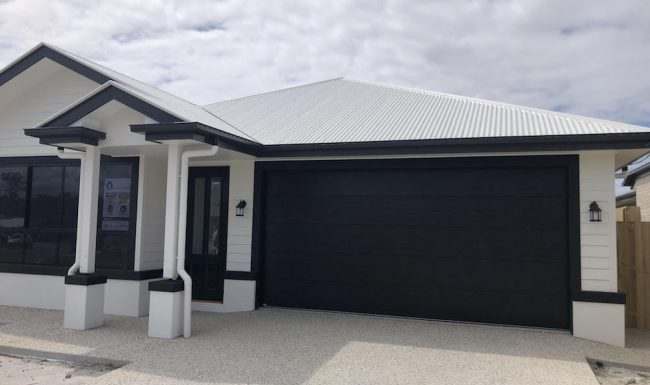 Wide flatline garage door with a dark woodgrain finish