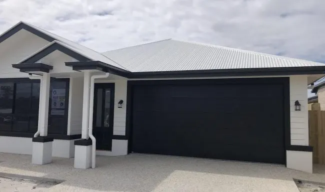 Wide flatline sectional garage door with a dark woodgrain finish