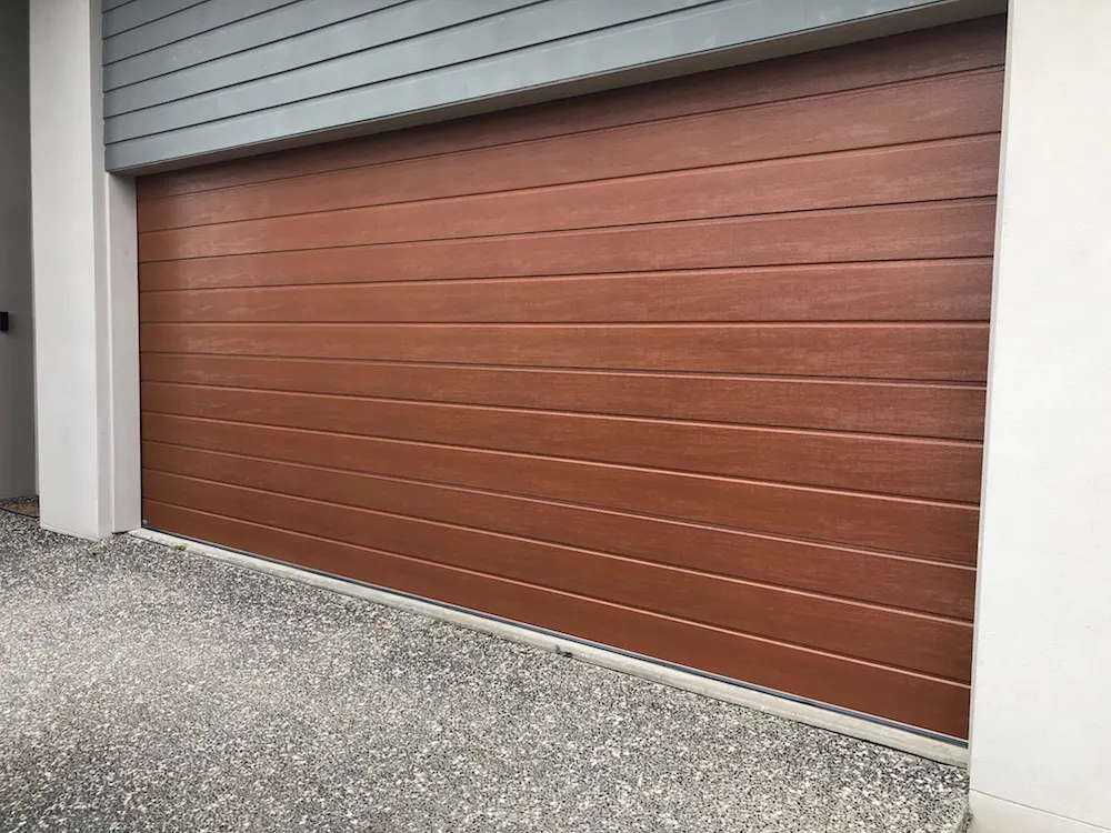 The same woodgrain sectional garage door after the front panelling was repaired